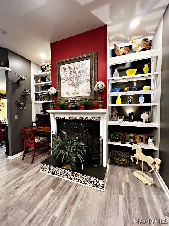 interior space with a fireplace, baseboards, and wood finished floors