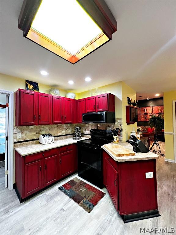 kitchen featuring light hardwood / wood-style floors, tasteful backsplash, and black range with electric cooktop