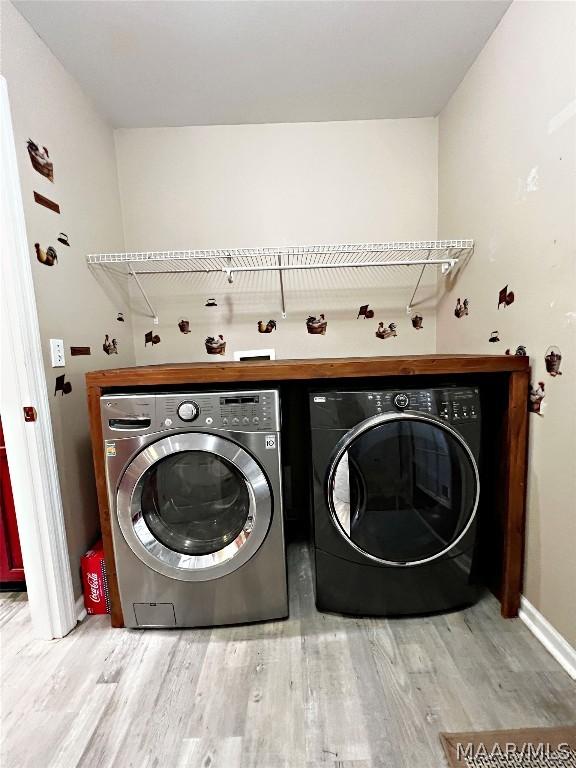 laundry room featuring laundry area, separate washer and dryer, and light wood-style flooring