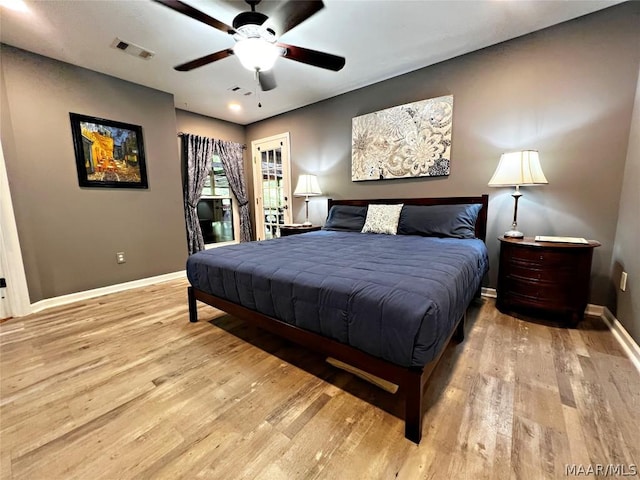 bedroom featuring light wood-type flooring, visible vents, and baseboards