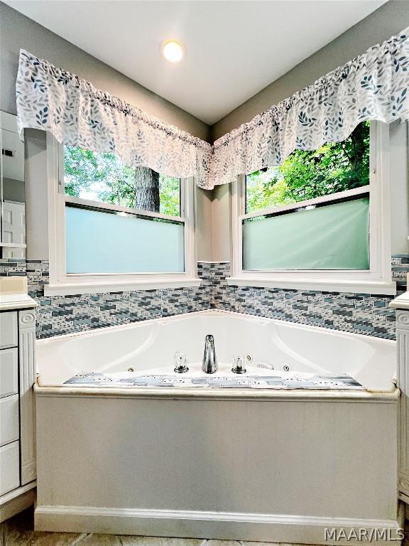 full bath with a whirlpool tub and vanity