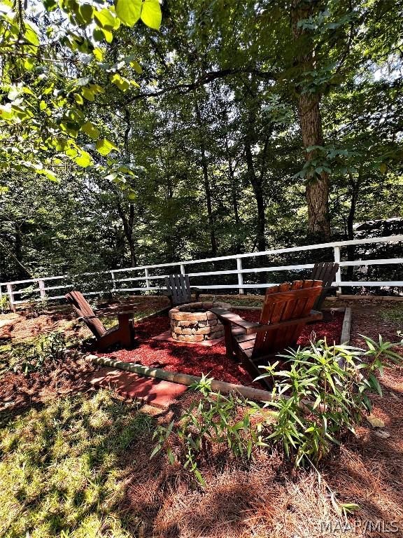 view of yard with an outdoor fire pit and fence