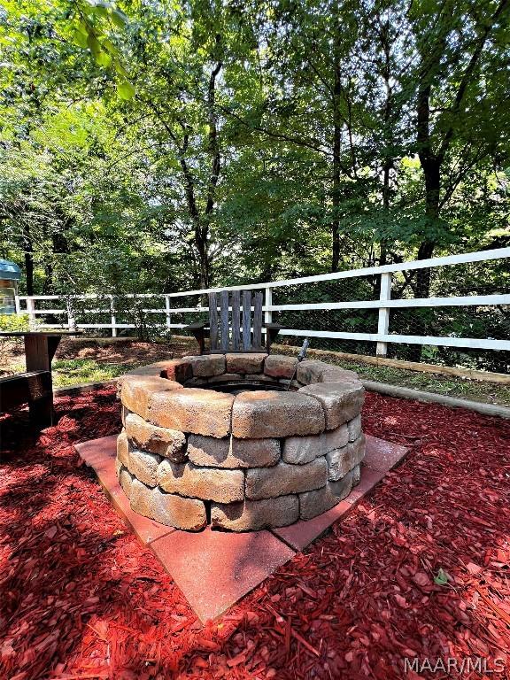 exterior space featuring an outdoor fire pit and fence