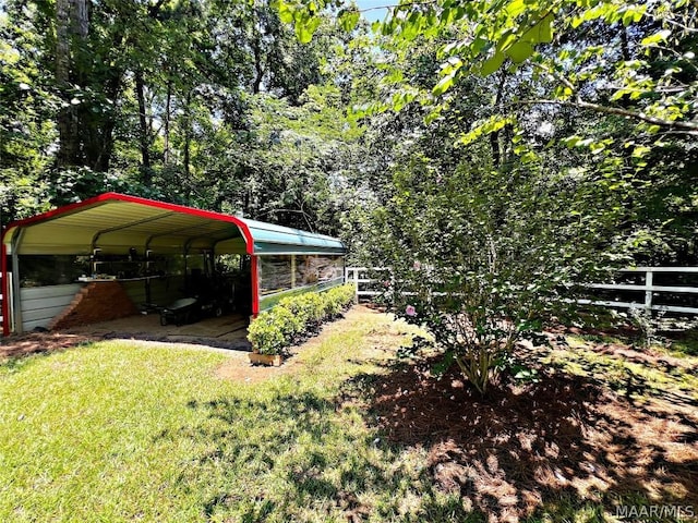 view of yard with fence and a detached carport