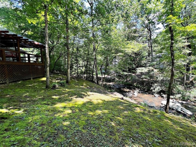 view of yard featuring a forest view and a pergola