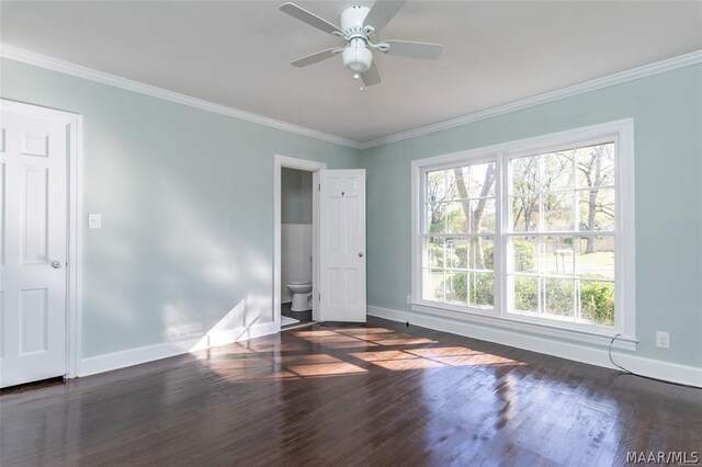 unfurnished bedroom featuring dark wood-type flooring, ensuite bath, ceiling fan, and crown molding