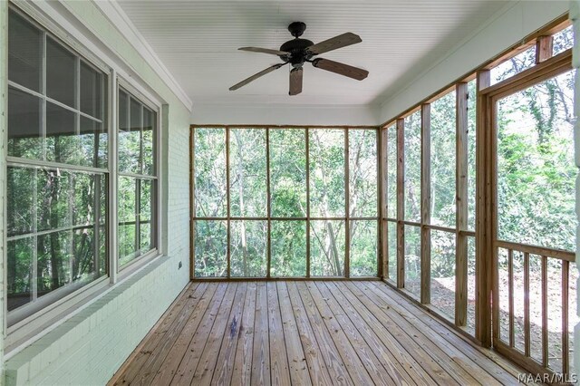 unfurnished sunroom featuring ceiling fan and a healthy amount of sunlight