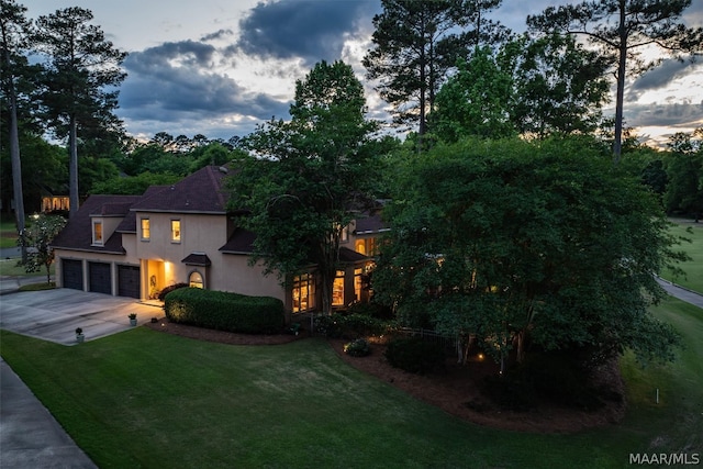 view of front of house with a garage and a yard