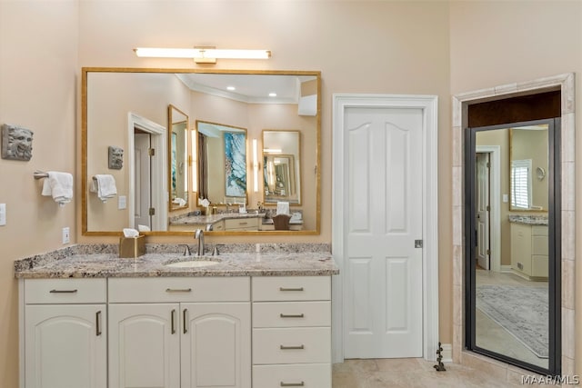 bathroom featuring vanity with extensive cabinet space, tile floors, and crown molding