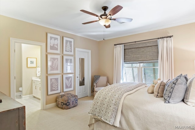 carpeted bedroom with ceiling fan, crown molding, and ensuite bathroom