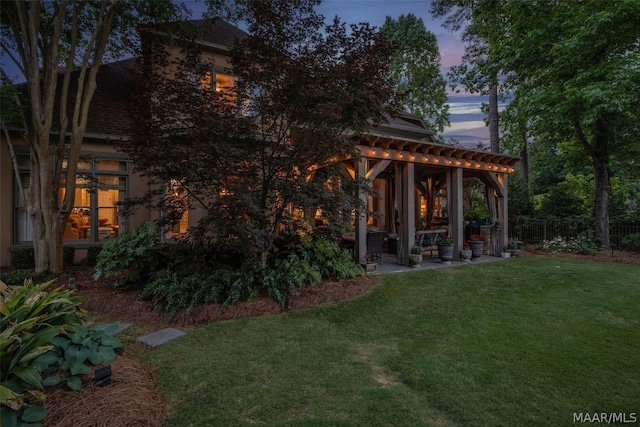 exterior space featuring a pergola, a patio area, and a lawn