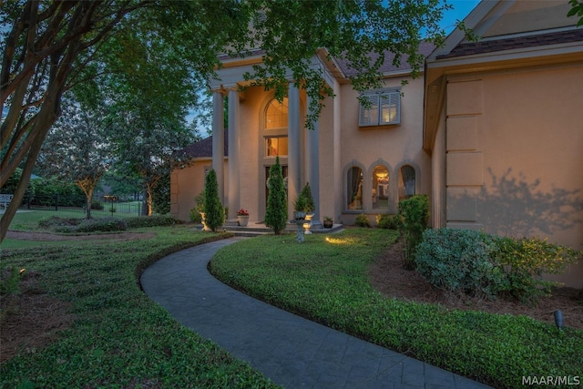 view of exterior entry with a yard