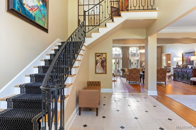 stairs with tile flooring and ornamental molding