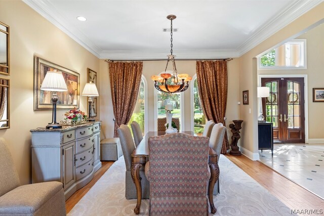 tiled dining space featuring an inviting chandelier, ornamental molding, and french doors