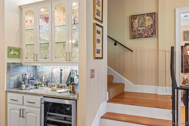 bar featuring white cabinetry, light stone countertops, tasteful backsplash, and wine cooler