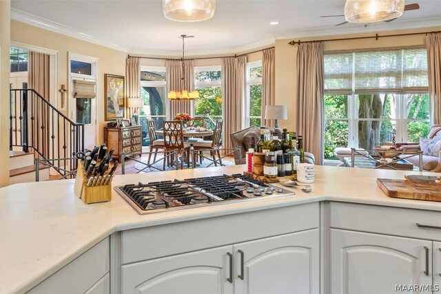 kitchen with white cabinetry, crown molding, stainless steel gas cooktop, and pendant lighting