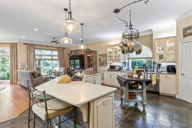 kitchen with a center island, crown molding, dark tile flooring, and dishwasher