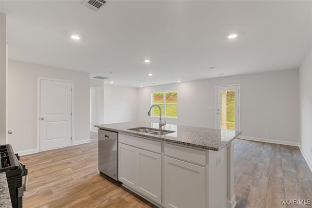 kitchen with sink, light hardwood / wood-style flooring, dishwasher, white cabinetry, and an island with sink