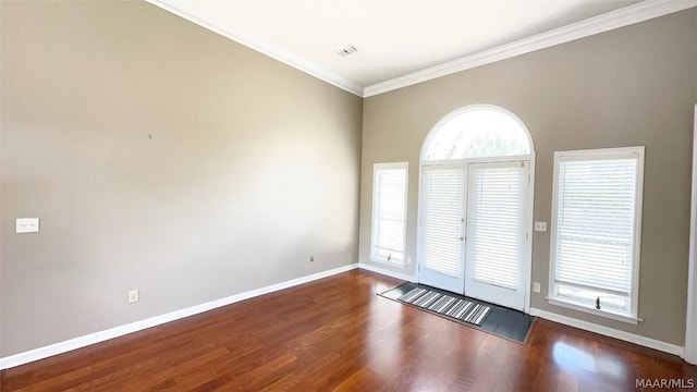 spare room featuring dark wood-type flooring and crown molding