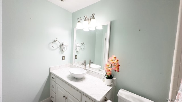 bathroom with vanity with extensive cabinet space and toilet