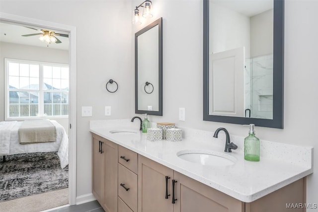 ensuite bathroom featuring ceiling fan, a shower with shower door, a sink, and double vanity