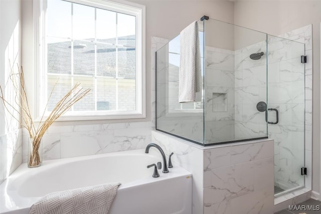 full bathroom featuring a garden tub and a marble finish shower