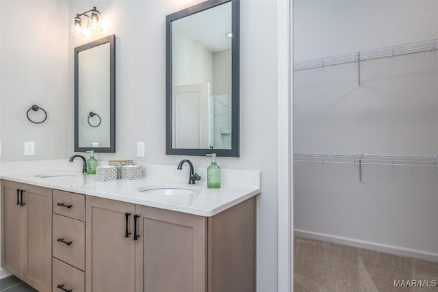 full bath with double vanity, a sink, and a walk in closet