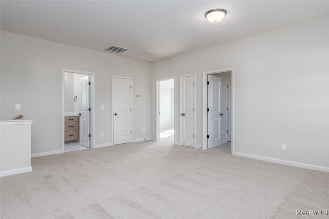 unfurnished bedroom with carpet, ensuite bath, visible vents, and baseboards