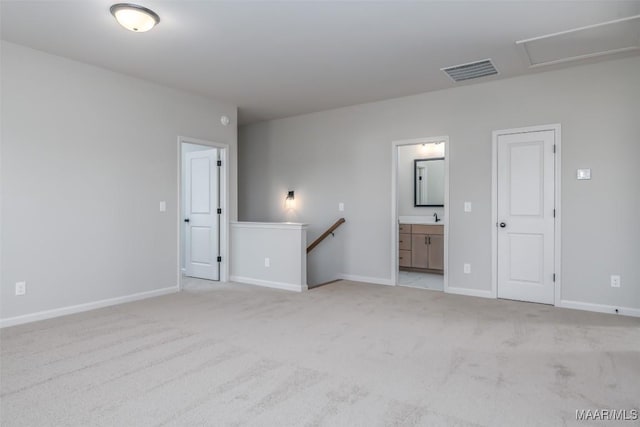 unfurnished bedroom with light carpet, a sink, visible vents, and baseboards