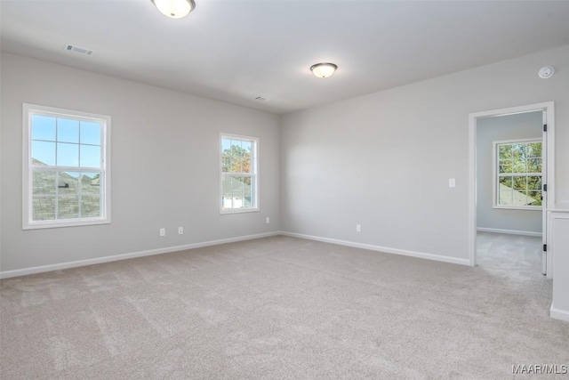 carpeted spare room featuring visible vents and baseboards