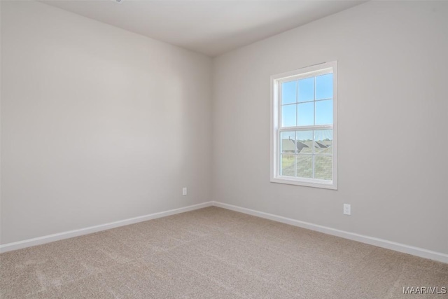 spare room featuring carpet floors and baseboards