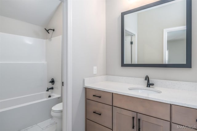 bathroom featuring toilet, marble finish floor, washtub / shower combination, and vanity