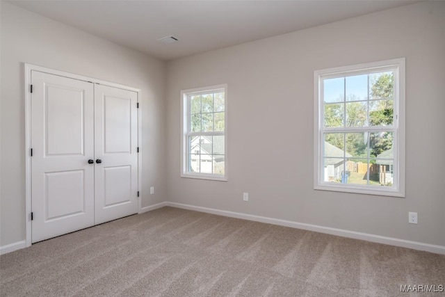 unfurnished bedroom with a closet, carpet flooring, and baseboards