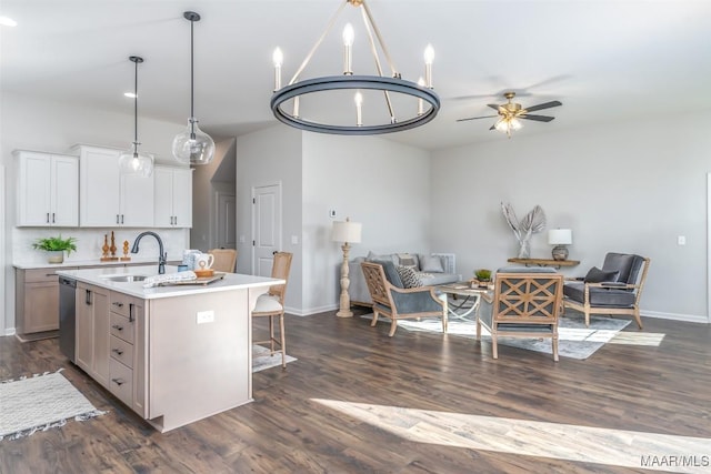 kitchen with open floor plan, a kitchen island with sink, a sink, and stainless steel dishwasher