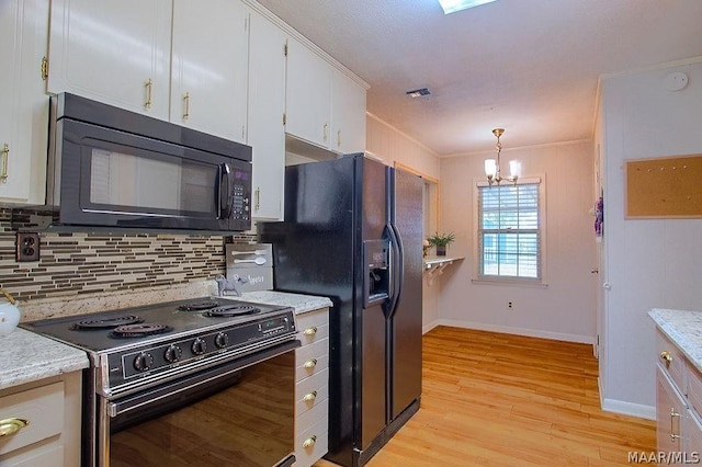 kitchen featuring tasteful backsplash, black appliances, pendant lighting, a chandelier, and white cabinetry