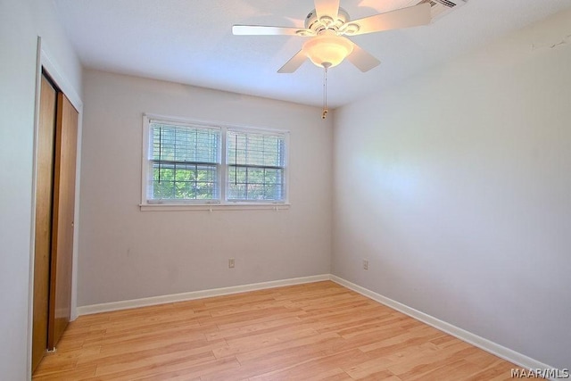 unfurnished bedroom featuring ceiling fan, light wood-type flooring, and a closet