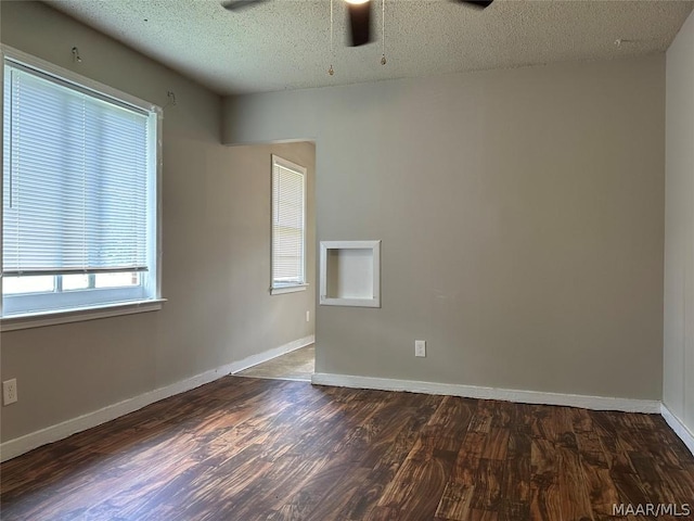 spare room featuring a textured ceiling, ceiling fan, and dark wood-type flooring