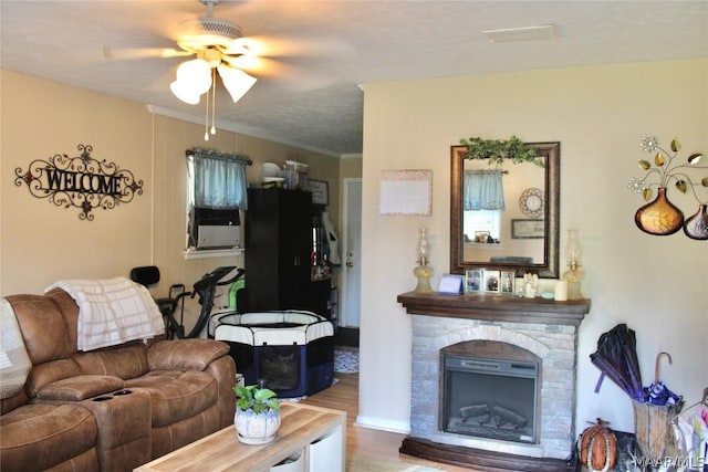 living room with a fireplace, wood-type flooring, a textured ceiling, and ceiling fan