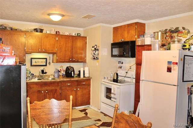 kitchen with a textured ceiling, white appliances, ornamental molding, and sink