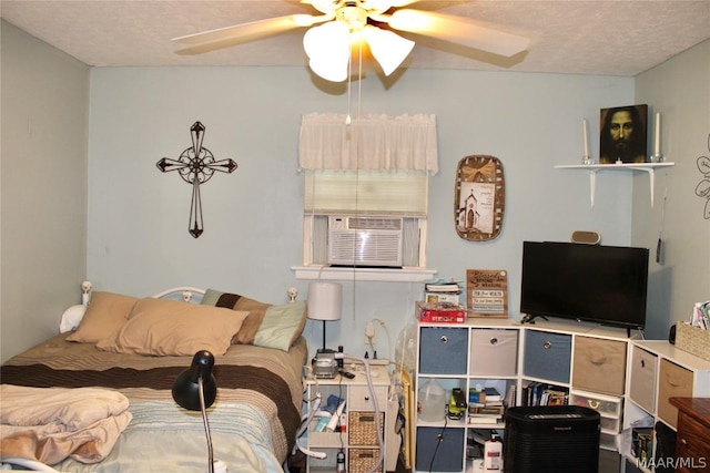 bedroom with ceiling fan, cooling unit, and a textured ceiling