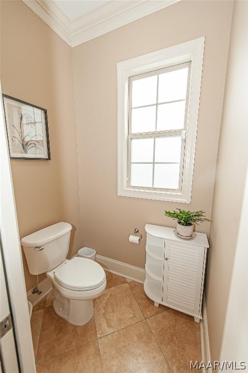 bathroom featuring crown molding, tile patterned floors, and toilet