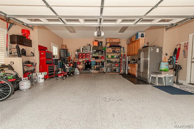 garage featuring stainless steel refrigerator with ice dispenser