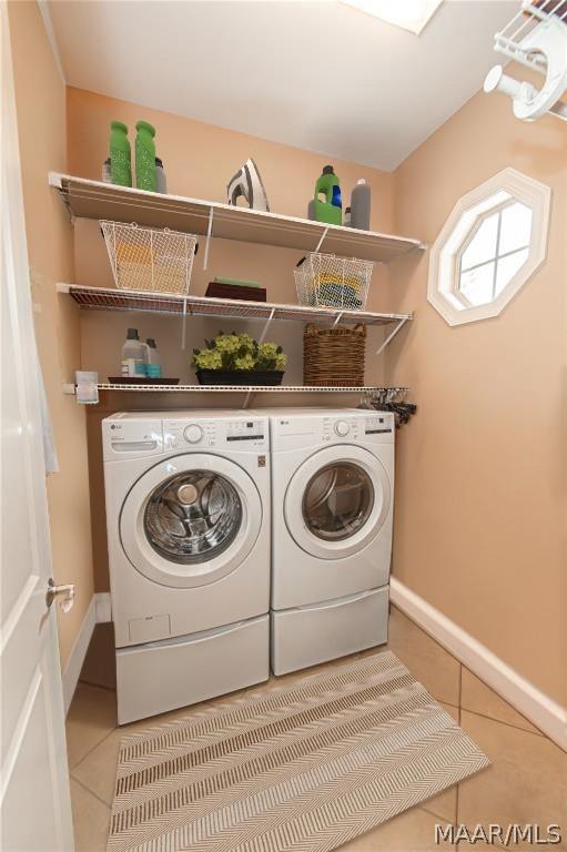 clothes washing area with independent washer and dryer and tile patterned floors