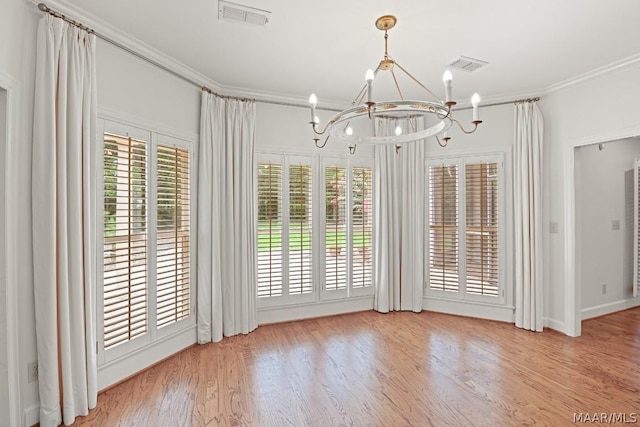 unfurnished dining area with ornamental molding, light hardwood / wood-style flooring, and an inviting chandelier