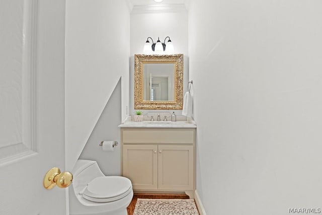 bathroom featuring vanity, toilet, and ornamental molding