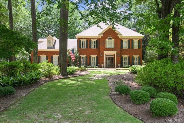 colonial inspired home featuring a front lawn