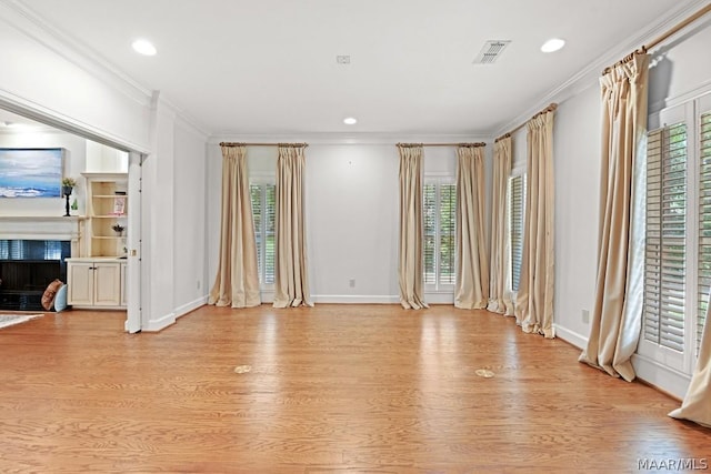 unfurnished living room featuring light hardwood / wood-style floors and crown molding