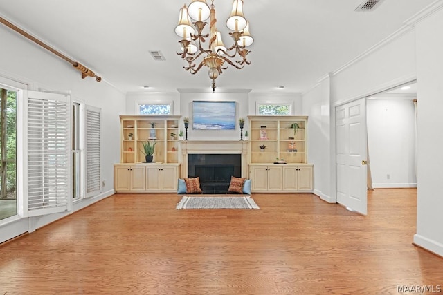 unfurnished living room featuring light hardwood / wood-style floors, an inviting chandelier, and ornamental molding