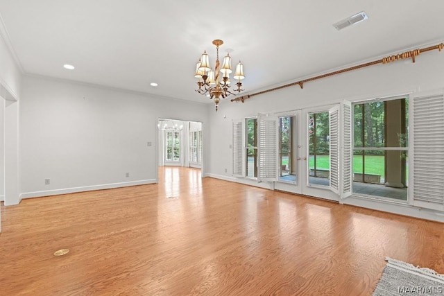 unfurnished living room featuring light hardwood / wood-style floors, an inviting chandelier, plenty of natural light, and ornamental molding