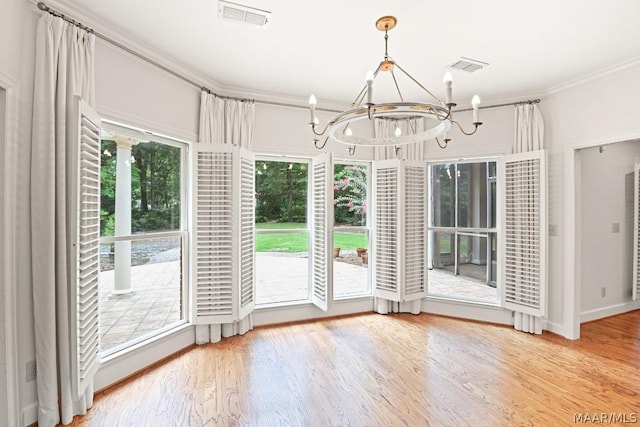 unfurnished dining area featuring hardwood / wood-style floors, ornamental molding, and a chandelier